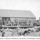 Passengers on railroad flatcars being pulled by Wild Goose Railroad's Climax Class A locomotive, probably Nome, ca. 1901